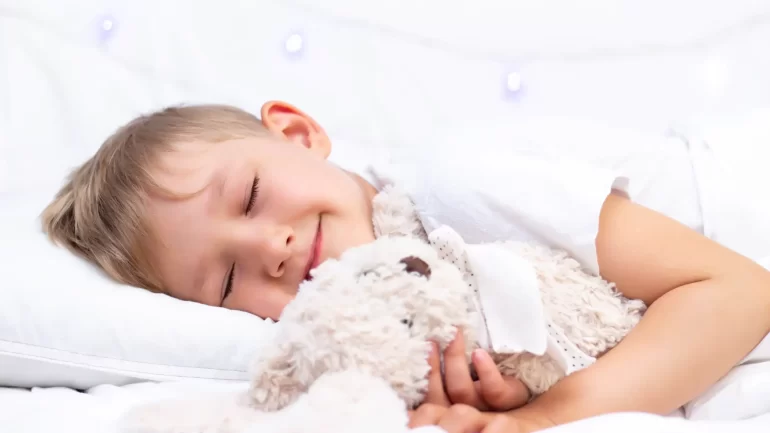 charming-little-white-boy-sleeps-bed-hugs-soft-toy